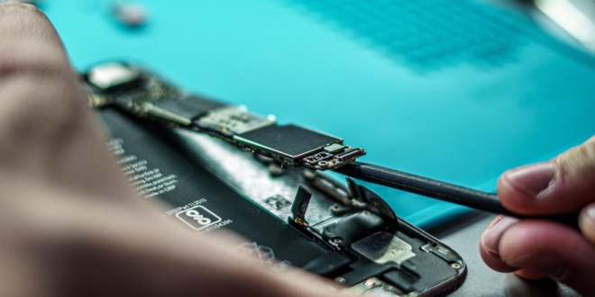 Technik v servise Itya opravujúci iPhone s profesionálnym vybavením a originálnymi náhradnými dielmi.