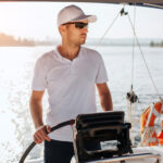 Kapitán riadi loď na mori počas rekreačnej plavby